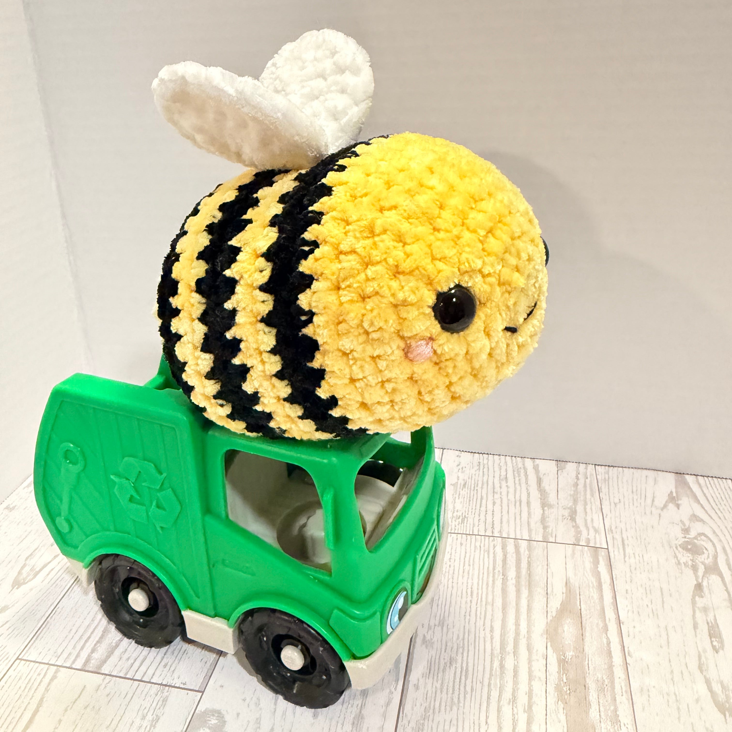 Crocheted bee toy on a green plastic car